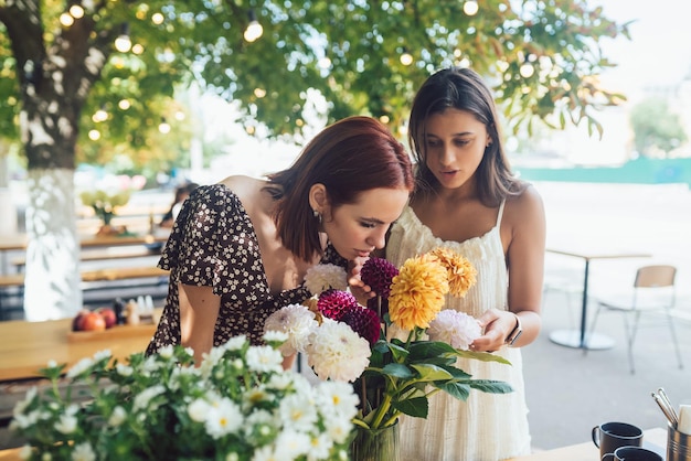 Due giovani donne compongono un bellissimo bouquet festivo