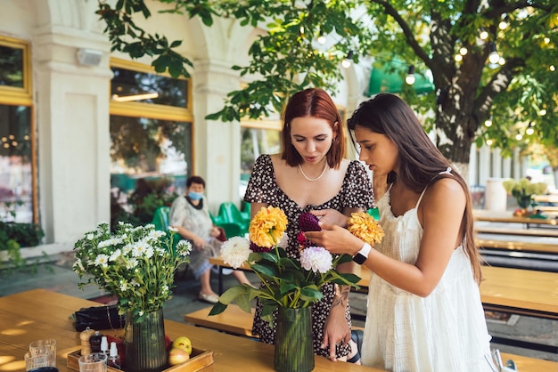 Photo two young women make up a beautiful festive bouquet