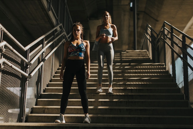 Two young women running in urban enviroment