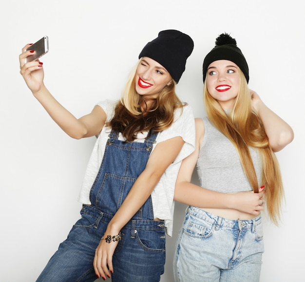 Two young women taking selfie with mobile phone 