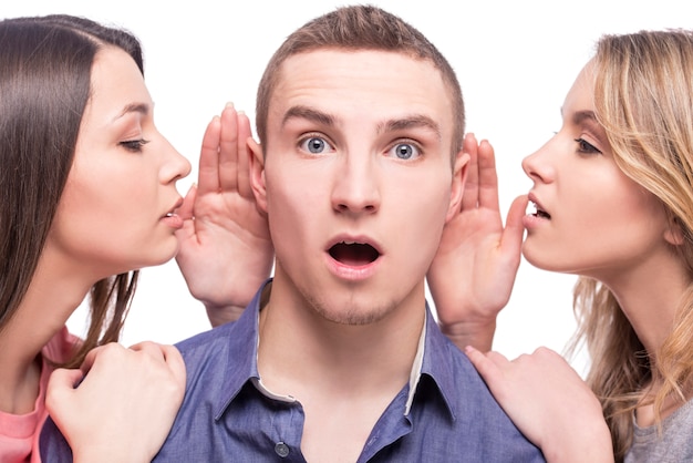 Two young women talking to the man.