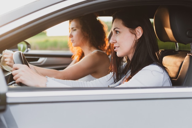 Two young women travel the roads in a car . Vacation concept