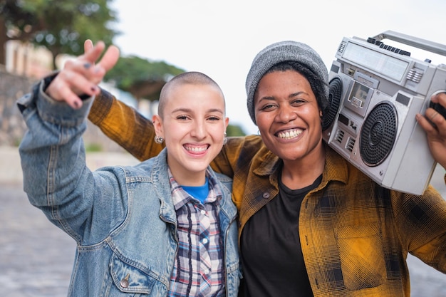 Two young women with urban style rapping with a boombox on their shoulders Concept Music lifestyle urban style