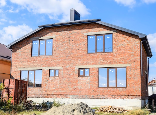 Twostorey house made of red brick Metalplastic windows Newly built house