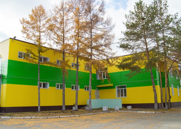 The twostoried building covered with beautiful yellow and green siding