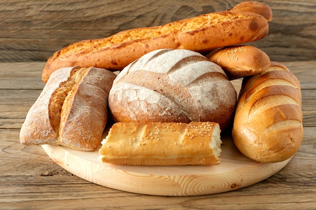 Types of homemade bread on the rustic wooden table. Homemade baked pastry.