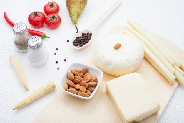 Types of various cheeses decorated with tomatoes, red pepper and pear