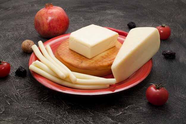 Types of various cheeses on a red plate