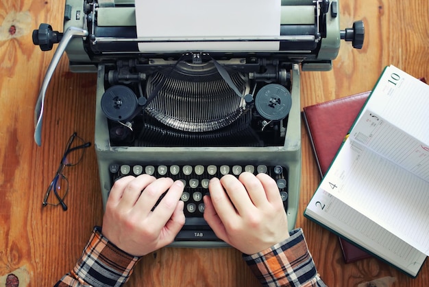 Фото Пишущая машинка ретро рука на деревянном столе
