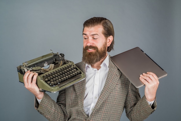 Фото Пишущая машинка против ноутбука журналист держит пишущую машинку и антиквариат для ноутбука, старый журналист, секретарь, юрист