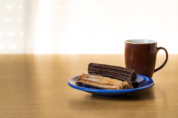 Typical Argentine churros with a cup of coffee on a table with copy space