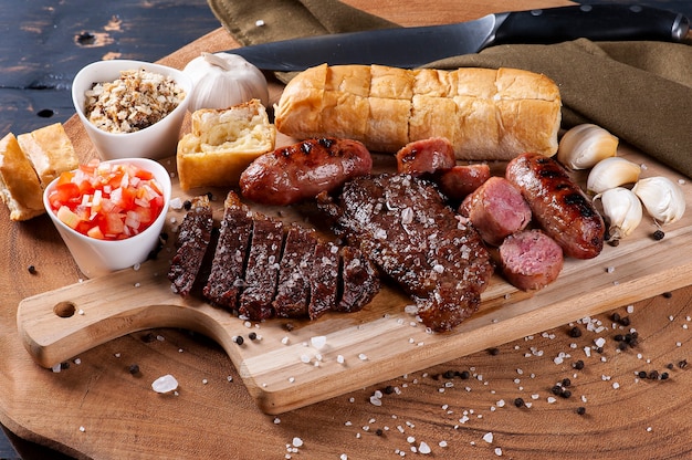 Typical Brazilian barbecue, with garlic bread, picanha, sausage, vinaigrette and farofa