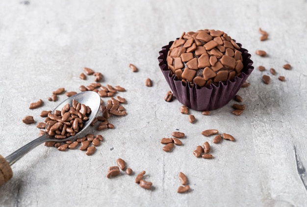 Tipici brigadeiros brasiliani con granelli di cioccolato su un tavolo di legno.