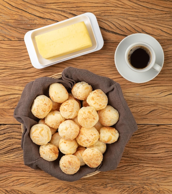 Typical brazilian cheese bun in a basket, coffee and butter.