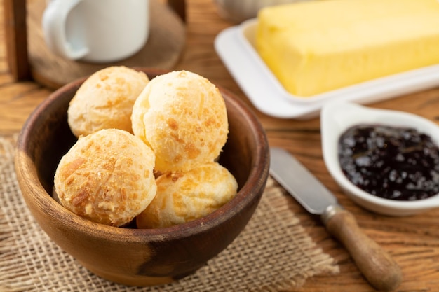 Typical brazilian cheese bun in a bowl, coffee, jam and butter.