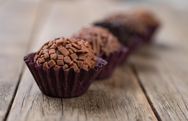 Typical brazilian chocolate brigadeiros over wooden table short depth of field