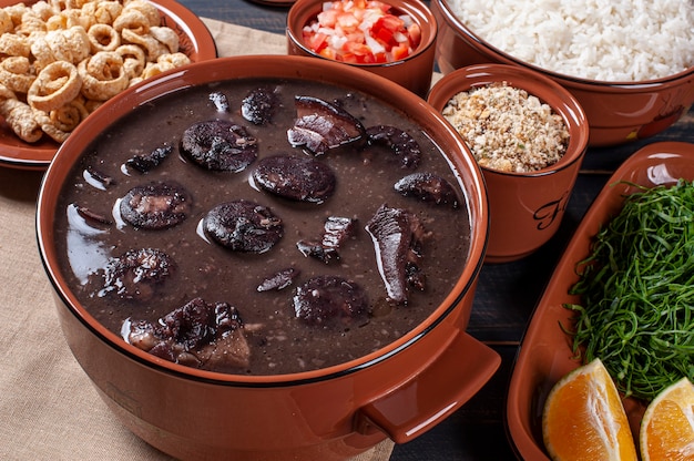 Foto piatto tipico brasiliano chiamato feijoada. a base di fagioli neri, maiale e salsiccia