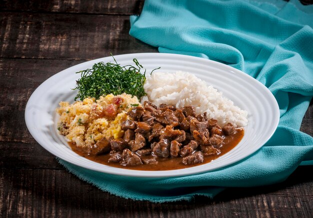 Typical brazilian dish, diced beef, rice, collard greens and egg crumbs.