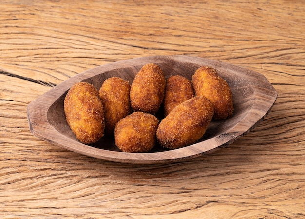 Typical brazilian jerked meat stuffed snack on a plate over wooden table