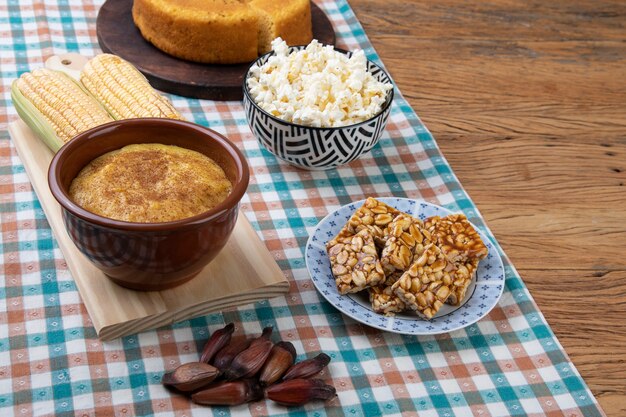 Cibo tipico del festival di giugno brasiliano sulla tovaglia su fondo di legno