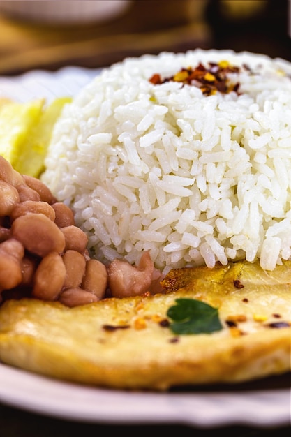 Типичный бразильский обед с рисом и фасолью, куриным филе на гриле и картофелем фри, домашняя еда