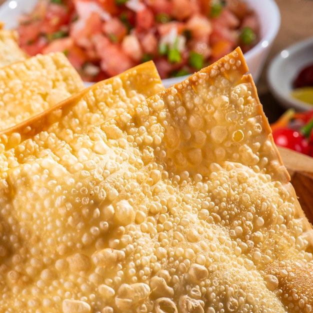 Typical Brazilian snack called Pastel. Accompanied by vinaigrette and pepper