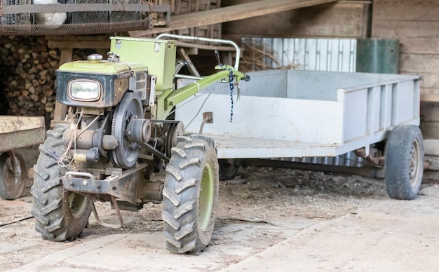 Tipico trattore a piedi diesel pesante con rimorchio attrezzature per il trasporto agricolo