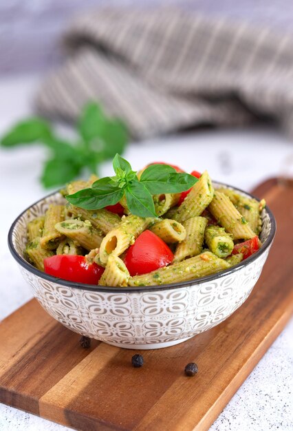 Foto piatto tipico italiano di fusilli integrali con pesto genovese e pomodorini