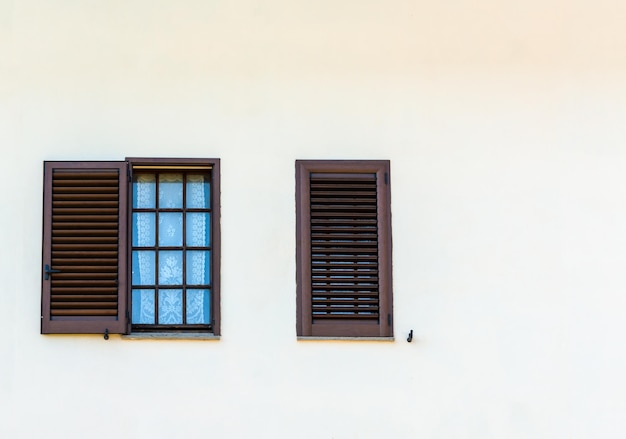 Typical italian shutter and windows to white wall