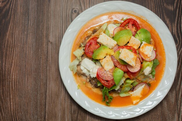 Typical Mexican dish called huarache in white plate on wooden table