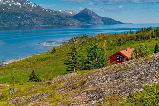 Typical Norwegian red house in the background of a picturesque fjord