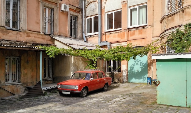 Typical old soviet courtyard with red car