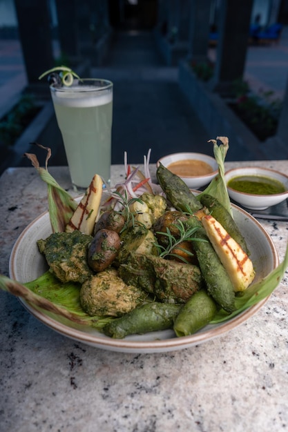 Piatto tipico peruviano, pachamanca, con alpaca, patata andina e diverse verdure.