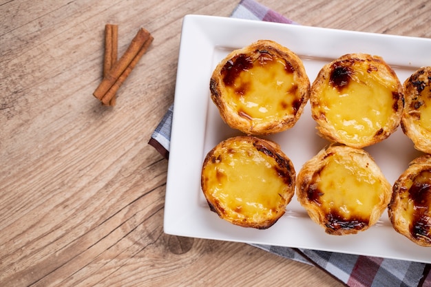 Typical Portuguese custard pies . traditional portuguese pastry. On a wooden table.