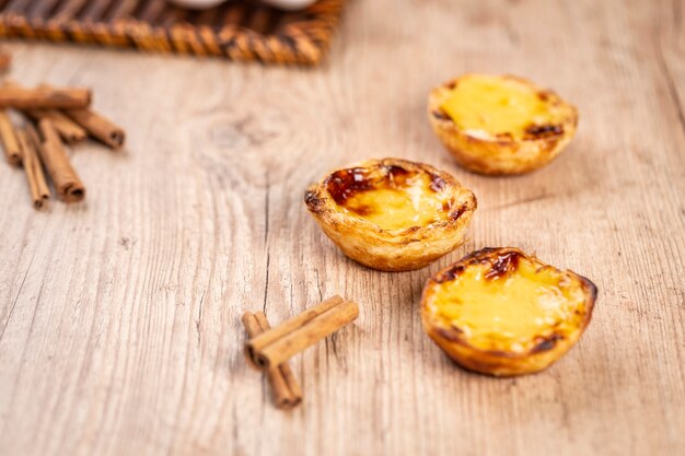 Typical Portuguese custard pies . traditional portuguese pastry. On a wooden table.