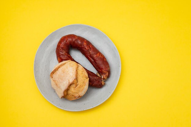 Typical portuguese smoked sausage chourico with corn bread on the plate