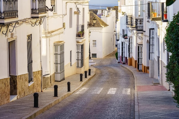 흰색으로 칠해진 집과 철창이 있는 창문이 있는 안달루시아 마을의 전형적인 거리 Medina Sidonia Cadiz