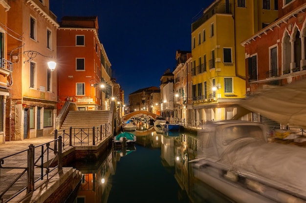 Typical Venetian canal with bridge at night Venice Italy