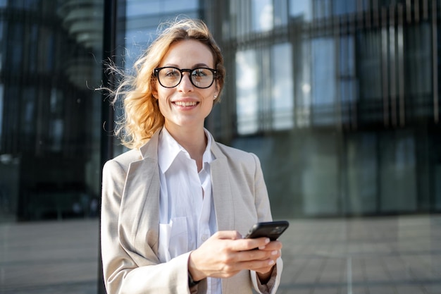 Typing a message for a colleague is a business woman using a mobile phone