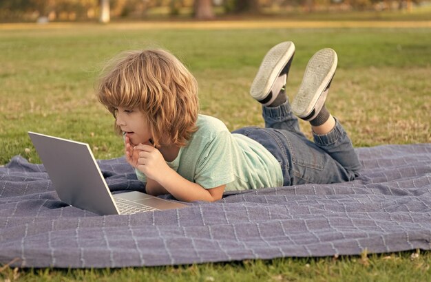 Typing school blog on computer small kid on video lesson teen boy use laptop