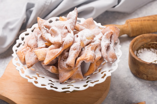 typisch Italiaanse carnaval beignets bestrooid met poedersuiker op betonnen tafel.