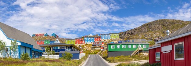 Typische architectuur van de Groenlandse stad Qarqotoq met gekleurde huizen gelegen nabij fjorden en ijsbergen