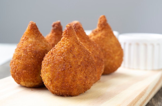 Foto typische braziliaanse snack coxinha op een houten bord.