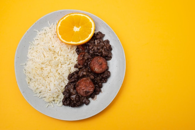 Typische braziliaanse voedselbonen met worstjes en rijst Feijoada op witte schotel