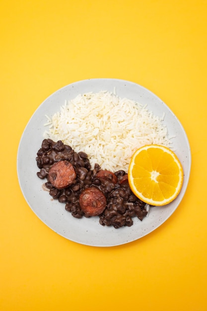 Typische braziliaanse voedselbonen met worstjes en rijst Feijoada op witte schotel