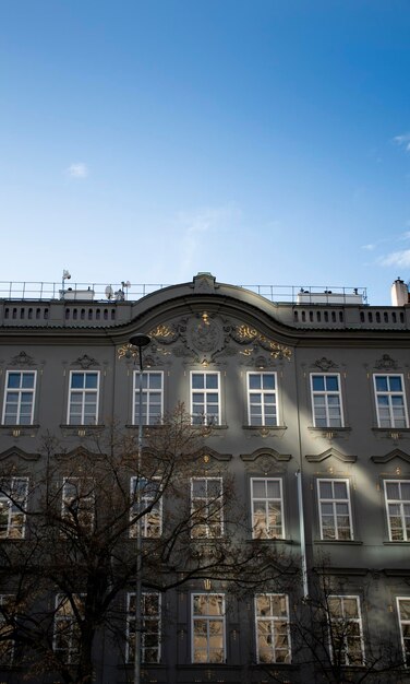 Typische Europese gevel van historisch hotelgebouw met ramen en gouden ornamenten met blauwe lucht