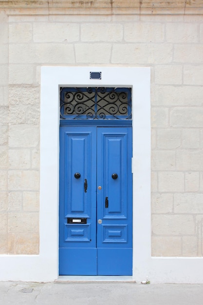 Typische Maltese blauwe houten oude deur op de kalksteenmuur Malta Concept van traditionele Maltese straatbeeld vintage architectuur