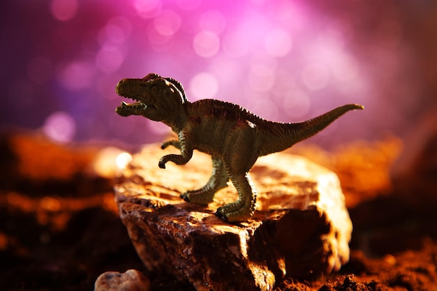 Foto silhouette di tyrannosaurus rex in fumo scenario creativo in fiamme con una piccola miniatura fine dell'era dei dinosauri