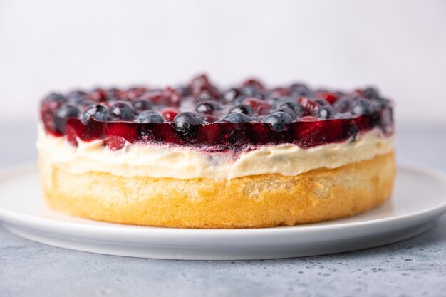 Tyrolean pie with soft custard cherries and blueberries Biscuit pie with light cream with fresh berries and jelly Traditional baking Closeup selective focus