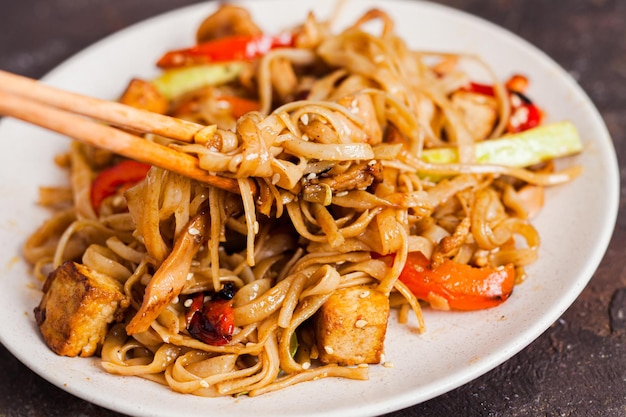 Foto udon noedels met tofu en groenten aziatische veganistische vegetarische maaltijd roerbak in de plaat